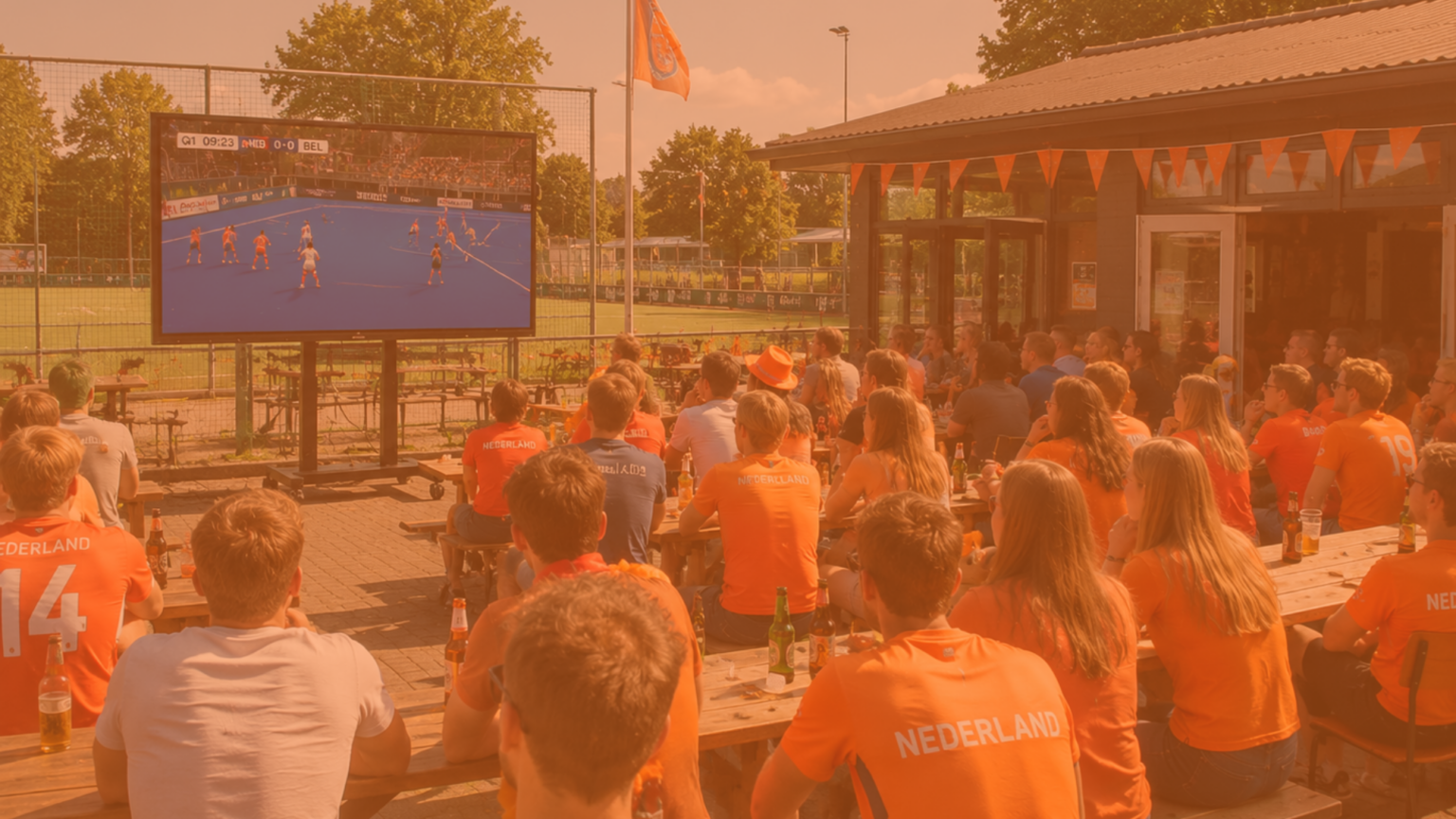 Supporters kijken op het terras van een hockeyclub naar een WK Hockey-wedstrijd op een groot professioneel scherm van DO-IT PRO-AV.